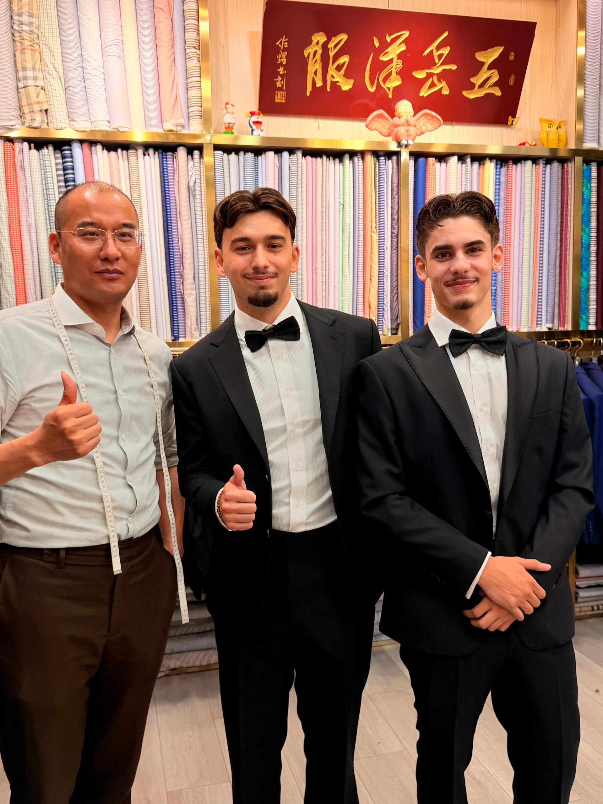 两位客户在五岳洋服门店试穿黑色礼服西装成衣
